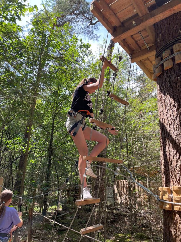 meisje vrouw op ladder in het bos klimmen