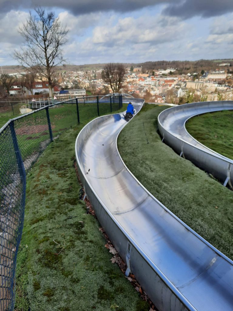 rodelen rodelbaan valkenburg glijbaan op berg met huizen op de achtergrond